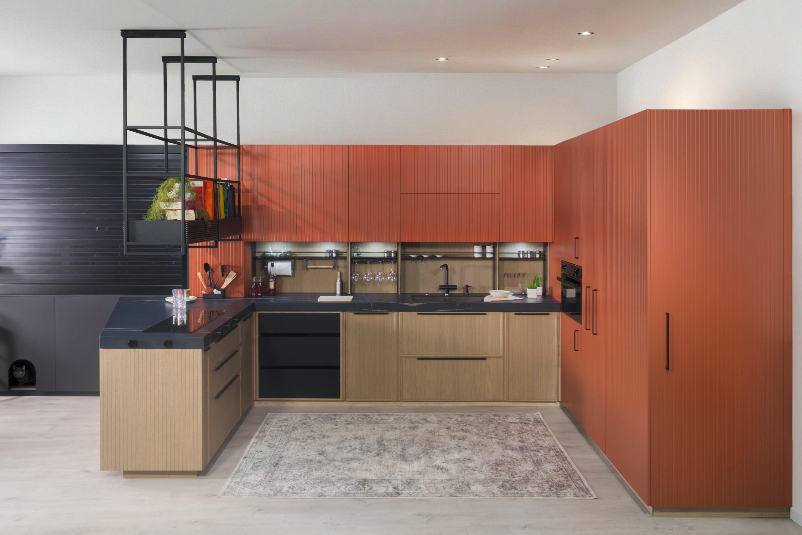 Cuisine moderne avec des armoires orange qui ajoutent une touche vibrante. Des plans de travail élégants et des appareils électroménagers fonctionnels complètent cet espace confortable et élégant. 