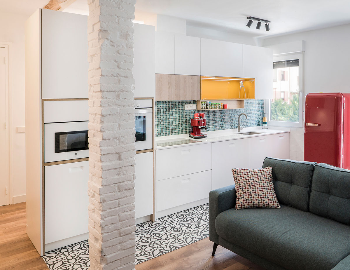 Una cocina moderna con un sofá cómodo, ideal para relajarse mientras se cocina. Un microondas elegante añade funcionalidad al espacio, combinando diseño y practicidad.